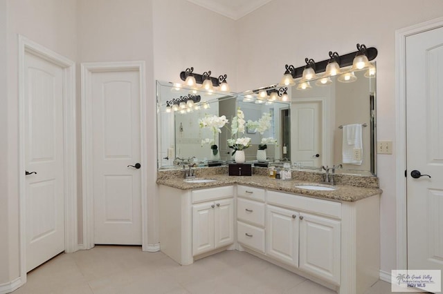 bathroom with ornamental molding, a sink, and double vanity