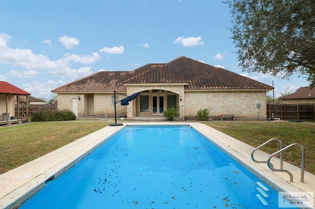 view of pool with french doors, a lawn, and a fenced in pool