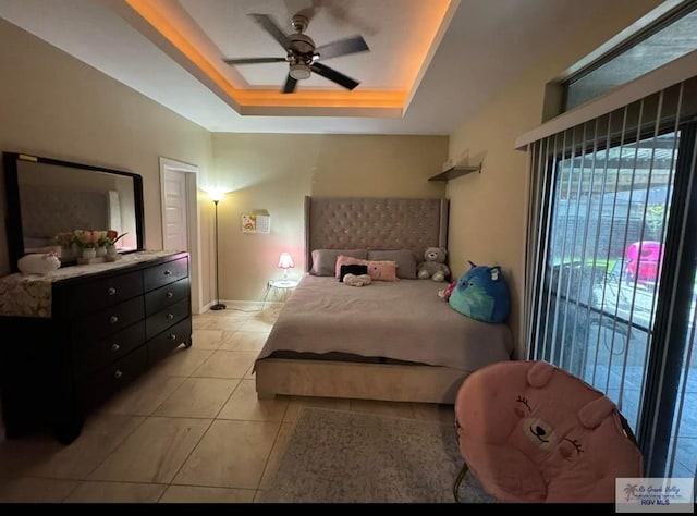 bedroom with a tray ceiling, access to exterior, baseboards, ceiling fan, and light tile patterned floors