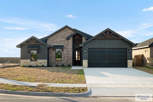 view of front of home with an attached garage, brick siding, fence, and driveway