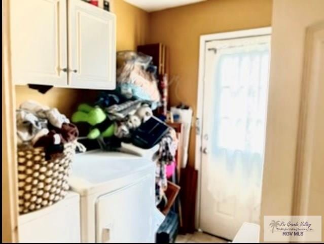 washroom with cabinets and washing machine and dryer