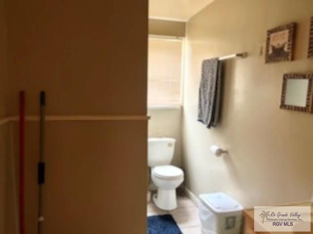 bathroom featuring toilet and tile patterned flooring