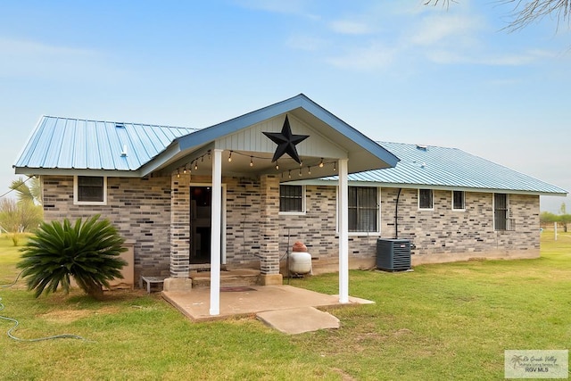 34719 Los Ranchos Rd Unit 1, San Benito, TX 78586 - back of property with a yard, a metal roof, a patio, and brick siding