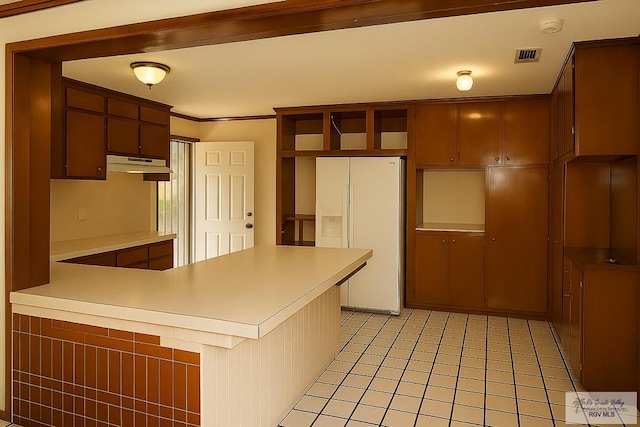 34719 Los Ranchos Rd Unit 1, San Benito, TX 78586 - kitchen with white fridge with ice dispenser, a peninsula, under cabinet range hood, light countertops, and ornamental molding