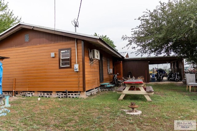 view of side of property featuring a lawn, cooling unit, and a carport