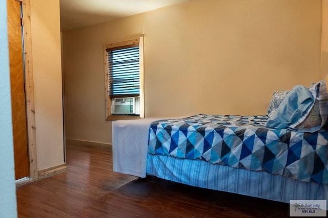 bedroom featuring cooling unit and dark hardwood / wood-style flooring