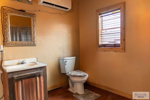 bathroom with a wall mounted air conditioner, vanity, toilet, and wood-type flooring