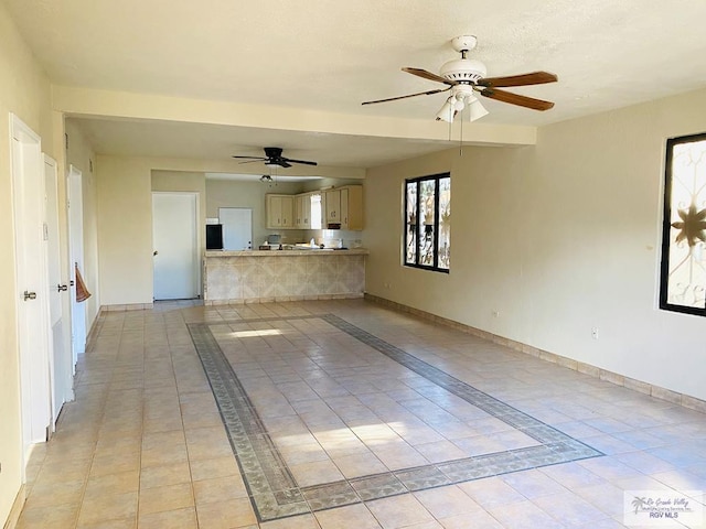 unfurnished living room featuring ceiling fan and light tile patterned floors