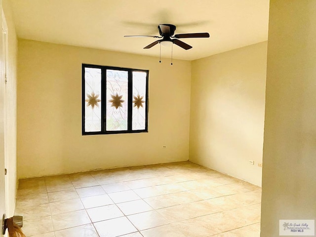 tiled spare room featuring ceiling fan