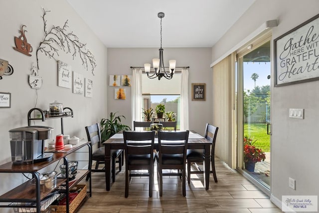 dining area with wood-type flooring and a chandelier