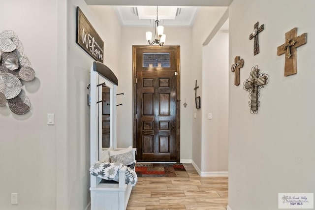 foyer entrance with a chandelier and light wood-type flooring