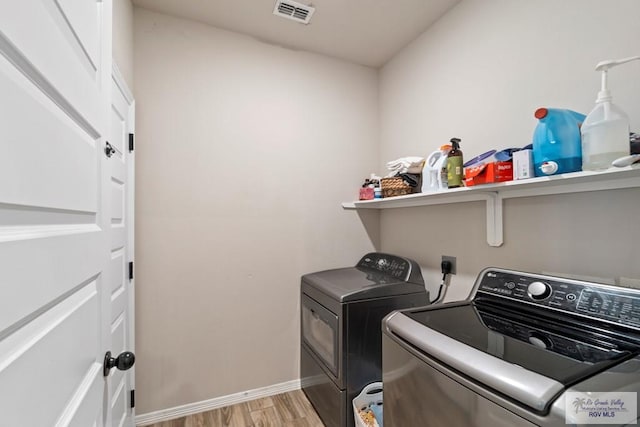 washroom with light wood-type flooring and washer and clothes dryer