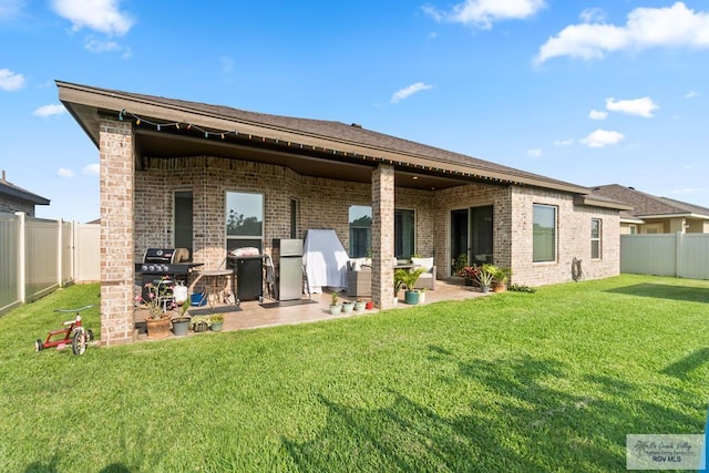 back of property with a yard and a patio