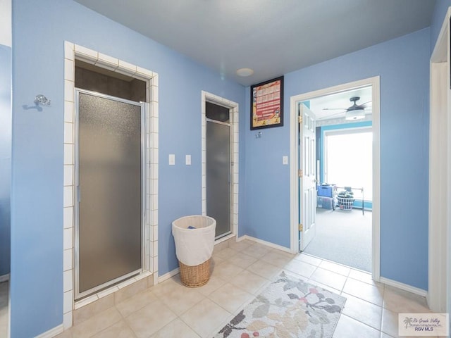 bathroom with tile patterned flooring, ceiling fan, and a shower with shower door