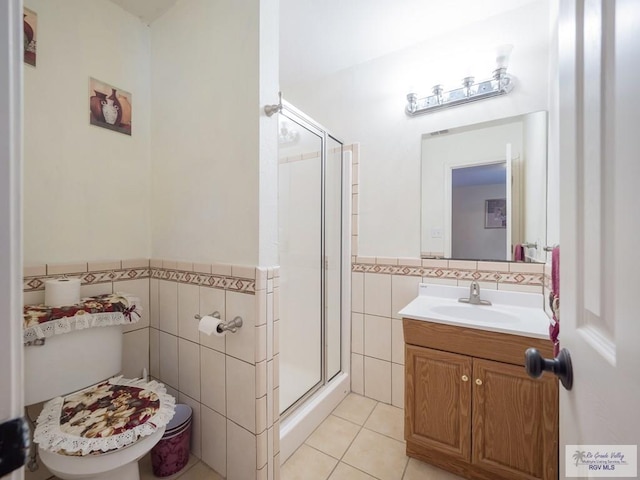 bathroom with walk in shower, tile patterned floors, toilet, vanity, and tile walls