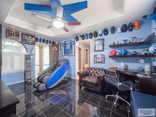 interior space with a tray ceiling and ceiling fan