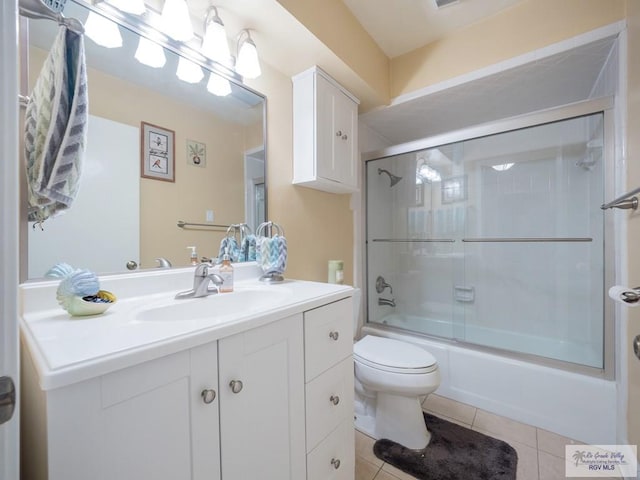 full bathroom featuring shower / bath combination with glass door, tile patterned flooring, vanity, and toilet