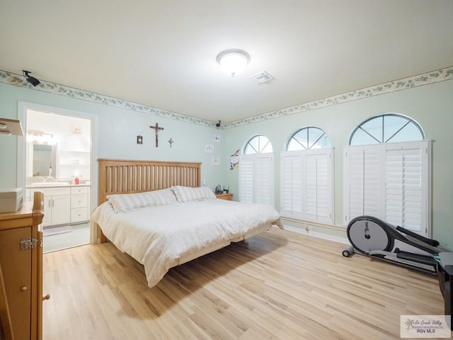 bedroom featuring light wood-type flooring and connected bathroom