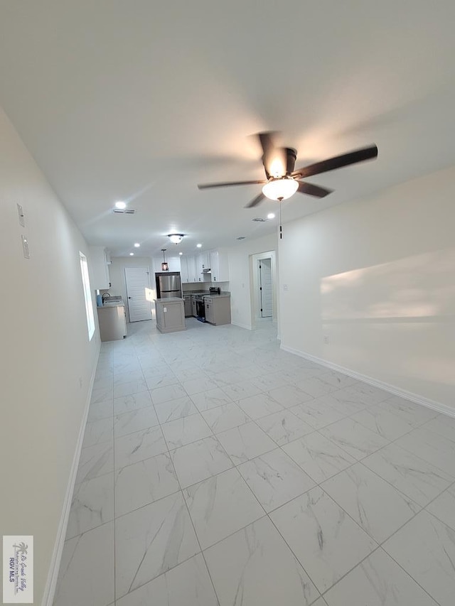 unfurnished living room with ceiling fan