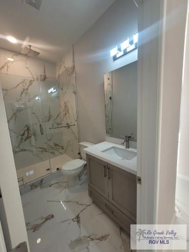 bathroom with a shower with door, vanity, and toilet