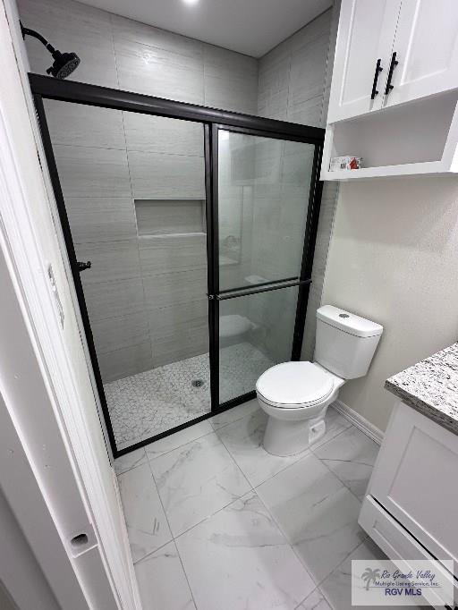 bathroom with vanity, toilet, and an enclosed shower