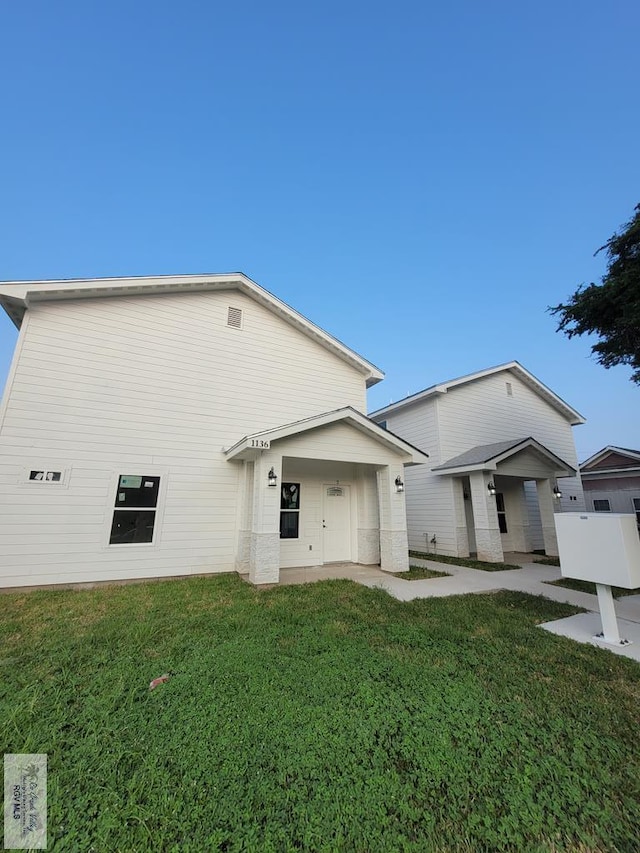 back of property featuring a lawn