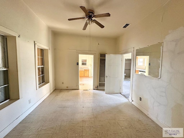 309 E Polk Ave, Harlingen, TX 78550 - unfurnished bedroom with tile patterned floors, ensuite bathroom, and a ceiling fan