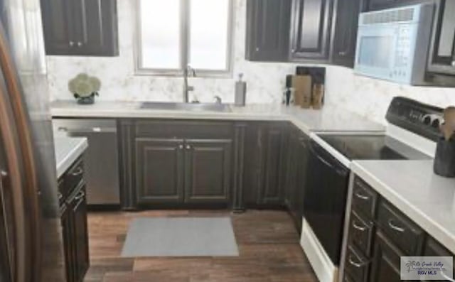 2201 Emerald Lake Dr, Harlingen, TX 78550 - kitchen featuring white appliances, light countertops, and dark wood-style floors