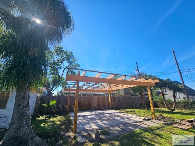 1115 Falcon Dr, Harlingen, TX 78550 - fenced backyard with a patio, a pergola, and a detached carport