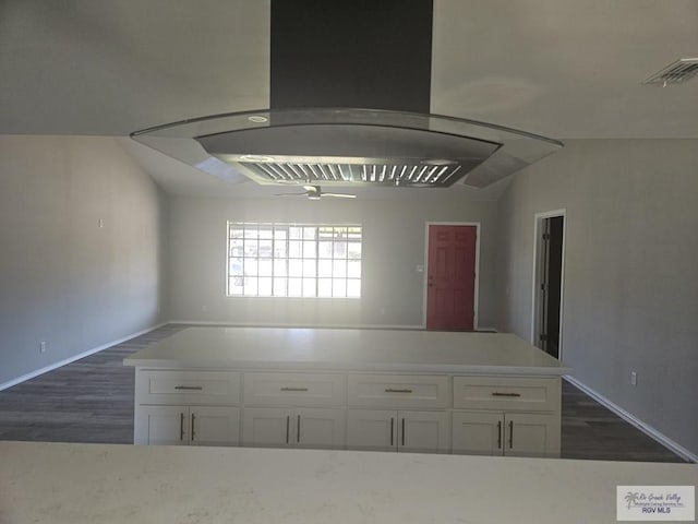 1115 Falcon Dr, Harlingen, TX 78550 - kitchen featuring island exhaust hood, white cabinets, dark wood finished floors, and light countertops