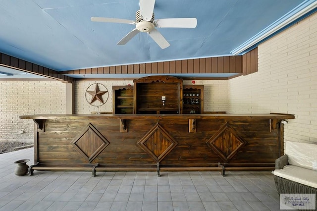 interior space featuring ceiling fan, brick wall, and lofted ceiling