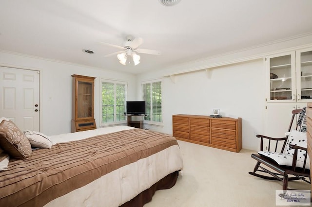 carpeted bedroom featuring ceiling fan and ornamental molding