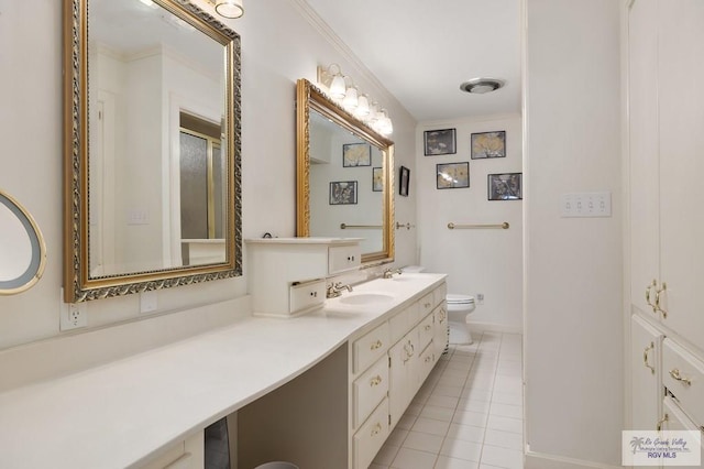 bathroom featuring tile patterned floors, vanity, toilet, and crown molding