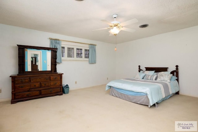 bedroom featuring ceiling fan, carpet floors, and a textured ceiling