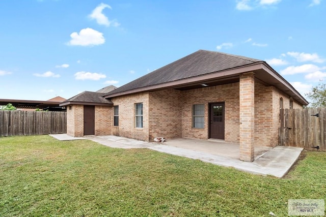 back of house featuring a patio area and a lawn