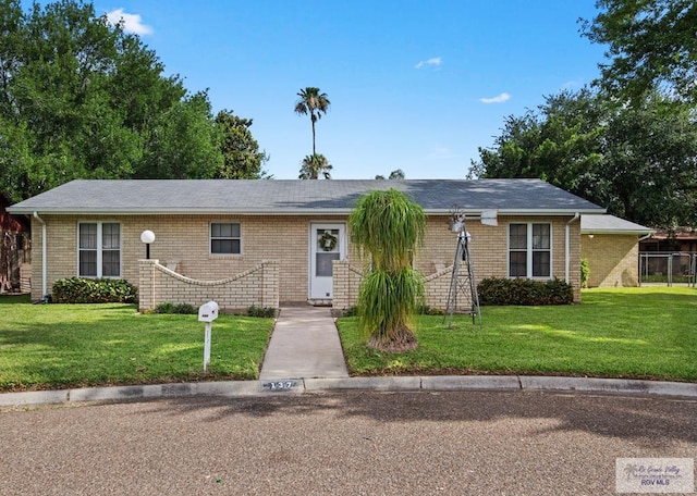 137 Ebano Ct, Harlingen, TX 78550 - ranch-style home featuring a front lawn and brick siding