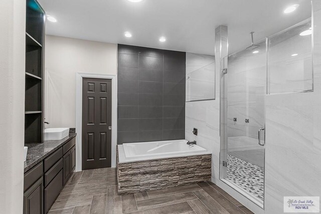 bathroom with shower with separate bathtub, vanity, and hardwood / wood-style flooring