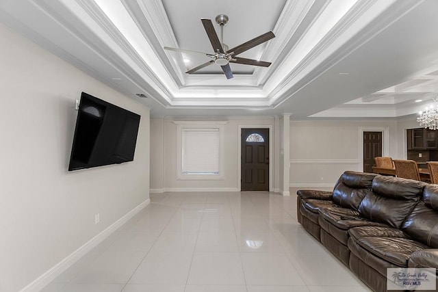 tiled living room with a raised ceiling, ceiling fan with notable chandelier, and ornamental molding