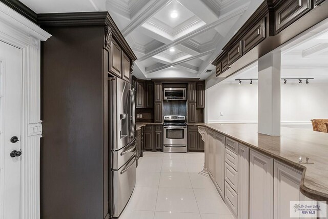 kitchen with beam ceiling, dark brown cabinetry, stainless steel appliances, coffered ceiling, and light tile patterned floors