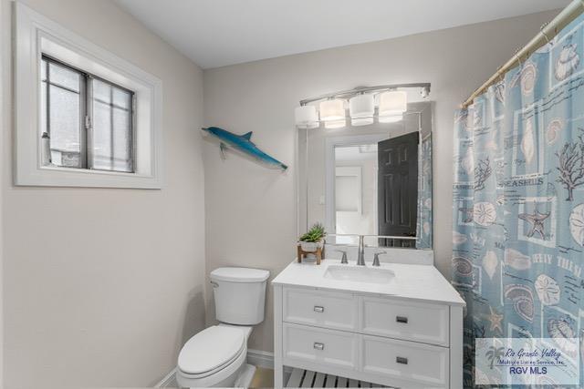 bathroom featuring vanity, a shower with shower curtain, and toilet