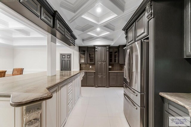 kitchen with stainless steel fridge, tasteful backsplash, coffered ceiling, crown molding, and beamed ceiling