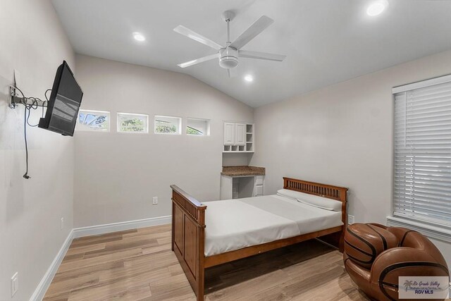 bedroom featuring ceiling fan, light hardwood / wood-style floors, and lofted ceiling