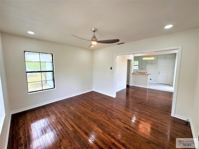 empty room featuring ceiling fan and dark wood-type flooring