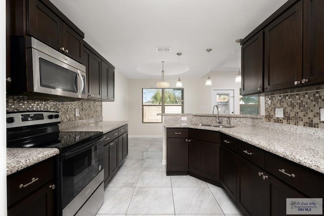 kitchen featuring dark brown cabinetry, sink, pendant lighting, and appliances with stainless steel finishes