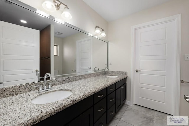 bathroom with tile patterned flooring and vanity