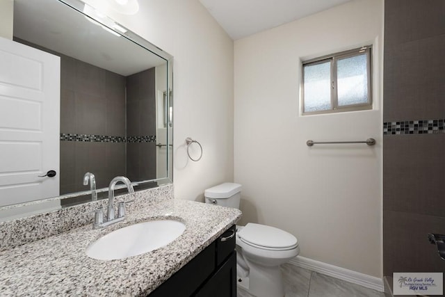 bathroom featuring tile patterned flooring, vanity, and toilet