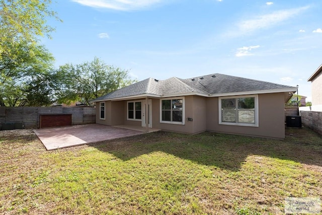 rear view of property with a yard, central AC unit, and a patio area