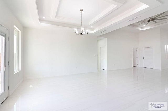 unfurnished room featuring a tray ceiling, a healthy amount of sunlight, visible vents, and ceiling fan with notable chandelier