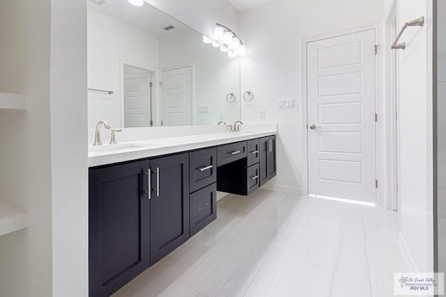 bathroom featuring double vanity, baseboards, visible vents, and a sink