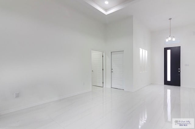 unfurnished room with marble finish floor, a high ceiling, baseboards, and recessed lighting